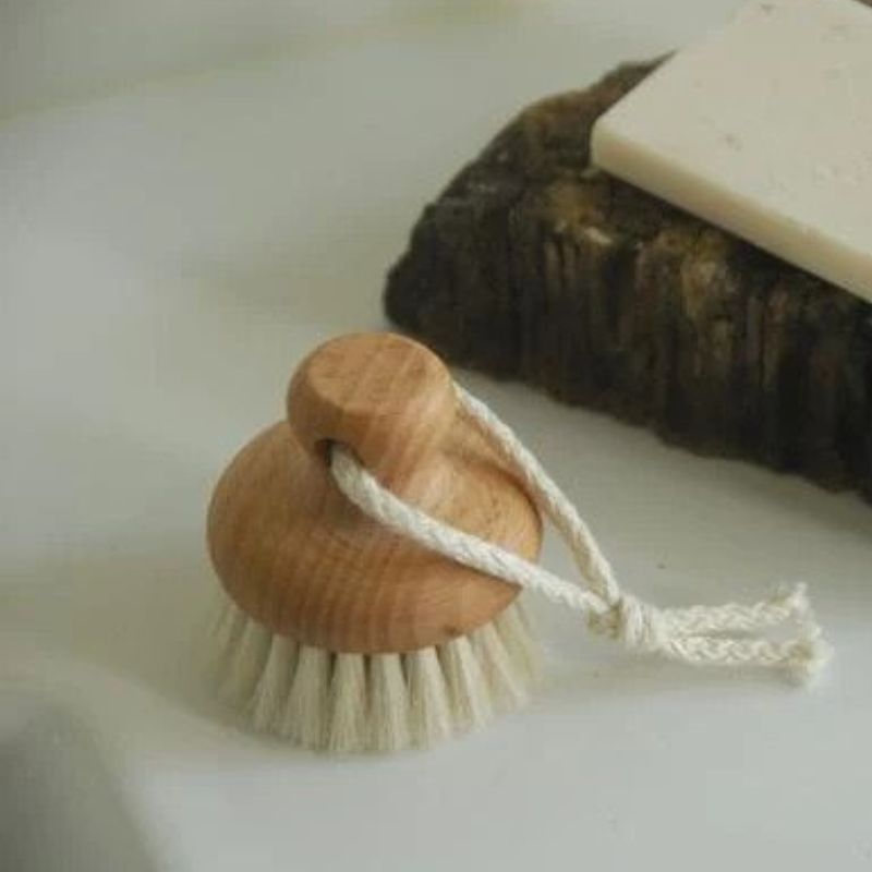 a wooden topped mane hair face brush with hanging cord