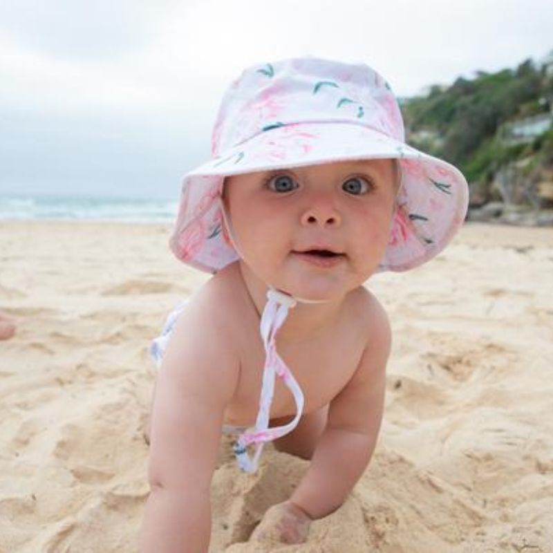 baby crawling on beach with peony print swim nappy and matching hat
