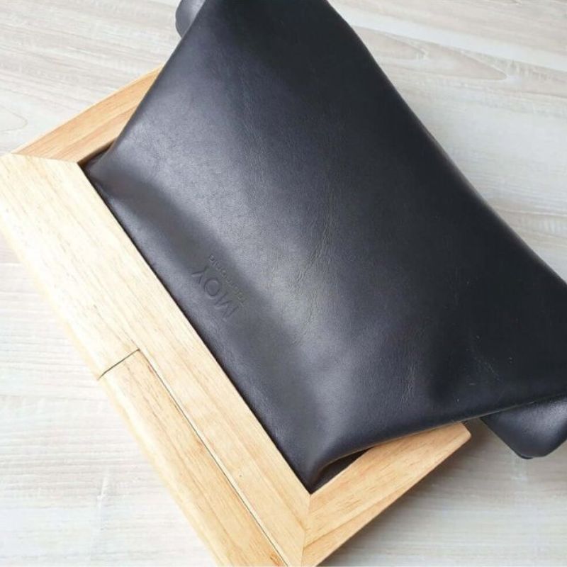 black leather and timber handled clutch showing plain leather back