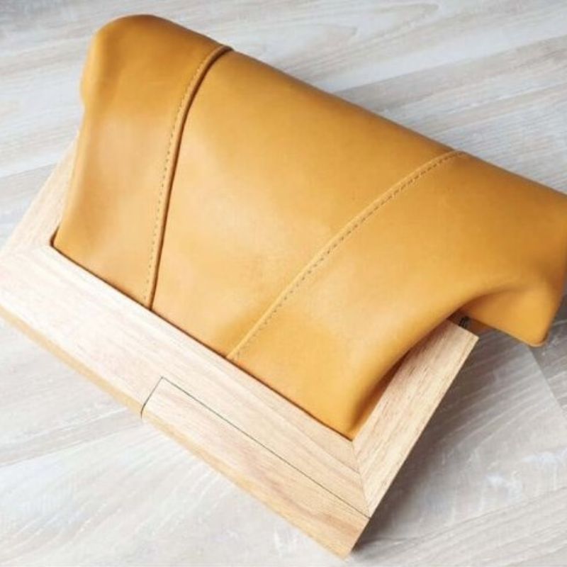 saffron yellow leather clutch with timber handle