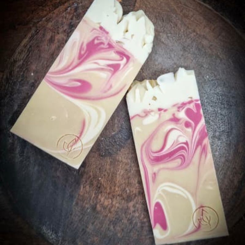 two wild rose soaps on a wooden bench