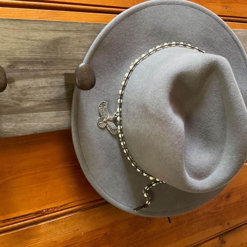 grey wool felt fedora with beads and eagle charm around crown