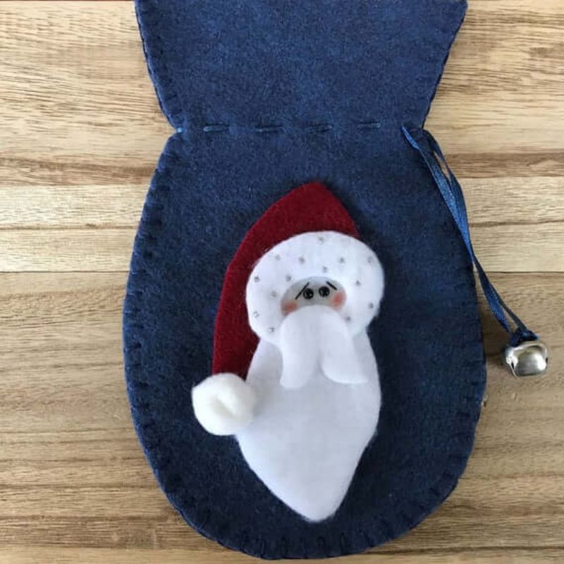 felt decoration ornament in the shape of a mitten with accented bell with an old fashioned santa on the front
