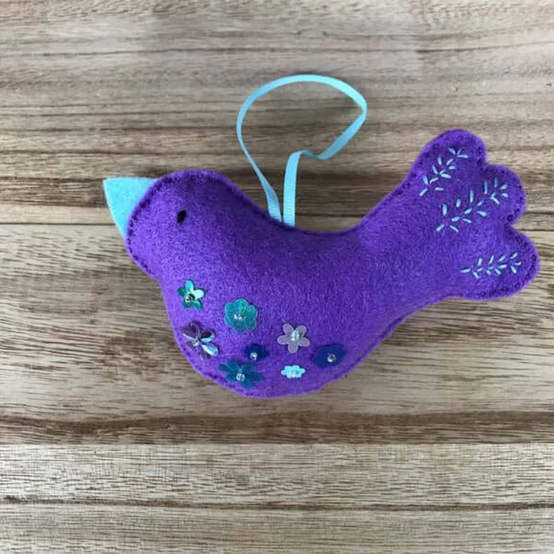purple bird ornament with blue beak and sequins