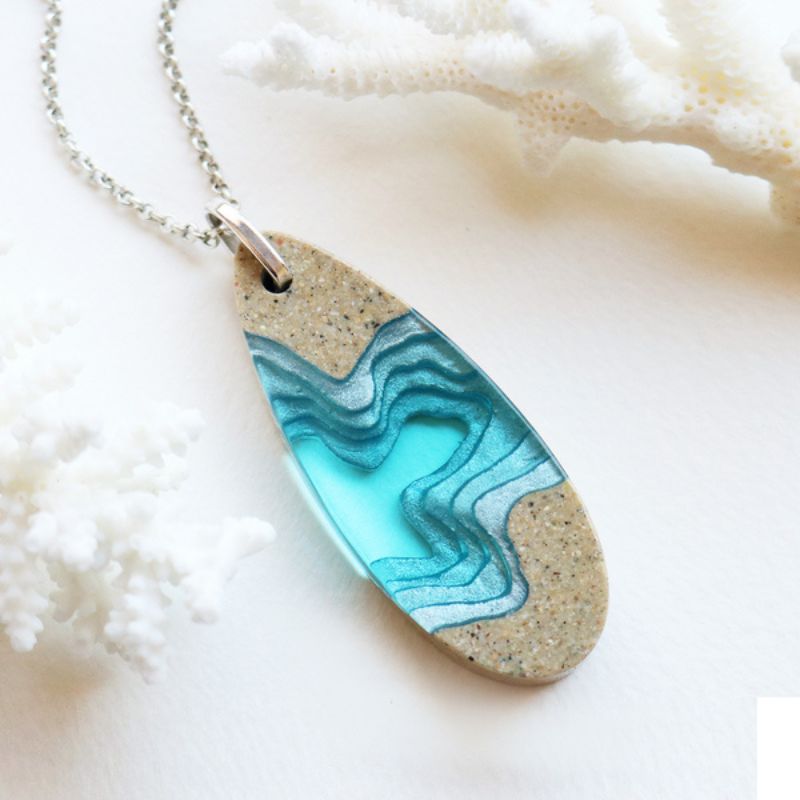resin and sand necklace with design of a fjord and made with sand and resin