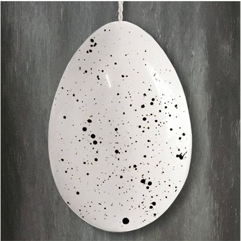white porcelain egg with speckled design and hanger