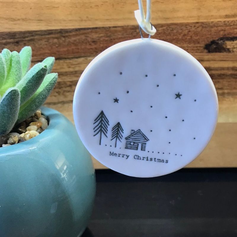 small round porcelain bauble merry christmas with picture of cabin and trees
