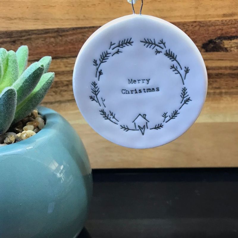 small round flat decoration ornament with a wreath and merry christmas