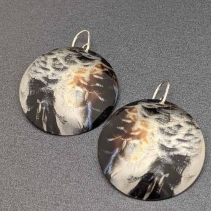 domed earrings with a photo of duck feathers transferred onto metal
