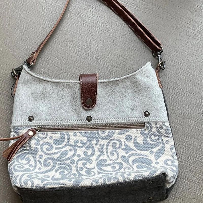 swirly grey pattern bag on the bottom half of front with other half being grey hair on leather
