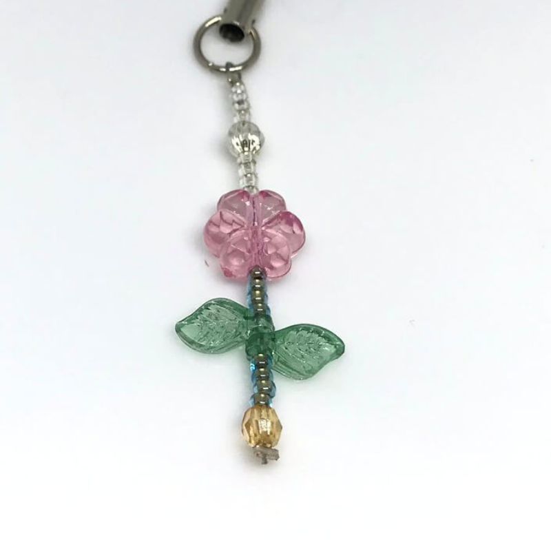 phone or bag charm with pink acrylic flower and green leaves