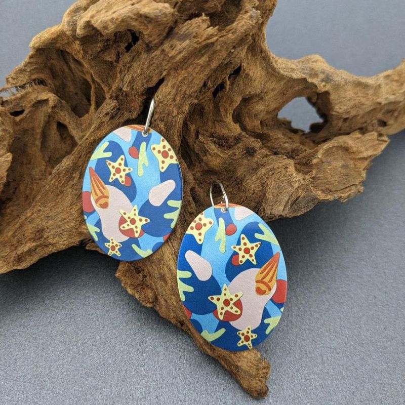 metal oval earrings with bright artwork of sea stars