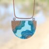 half circle necklace in a waterway topographical design with sand and blue resin