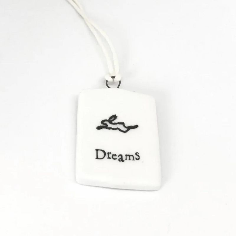 white porcelain tag with a black rabbit and the words dream