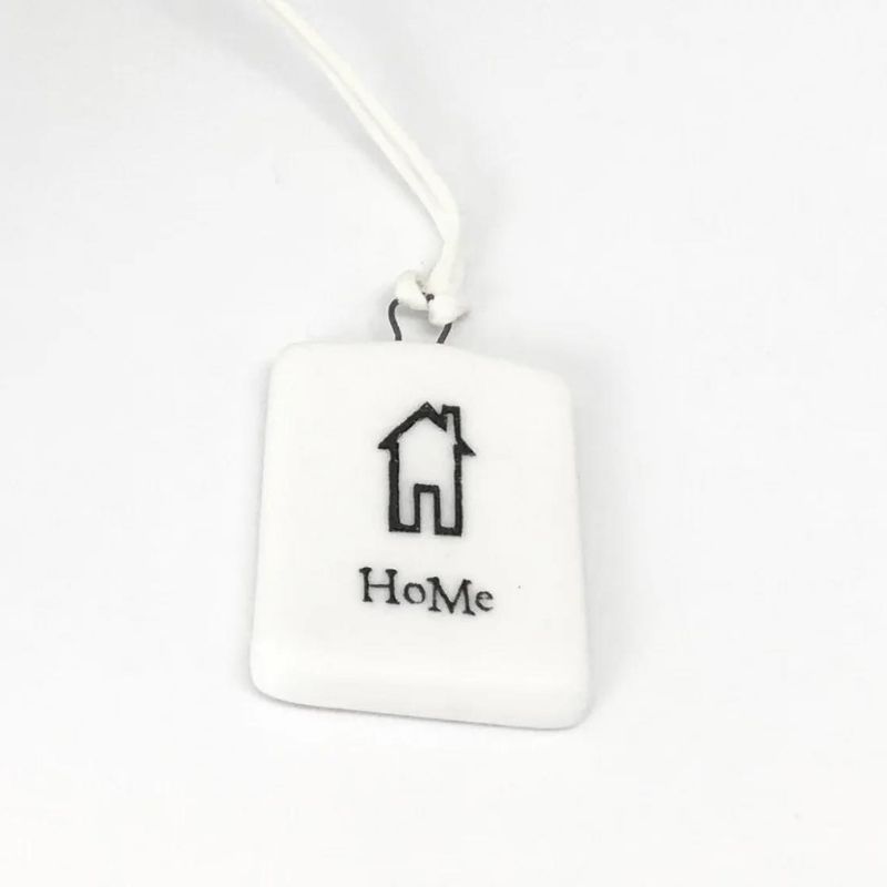 white porcelain tag with a black house and the word home
