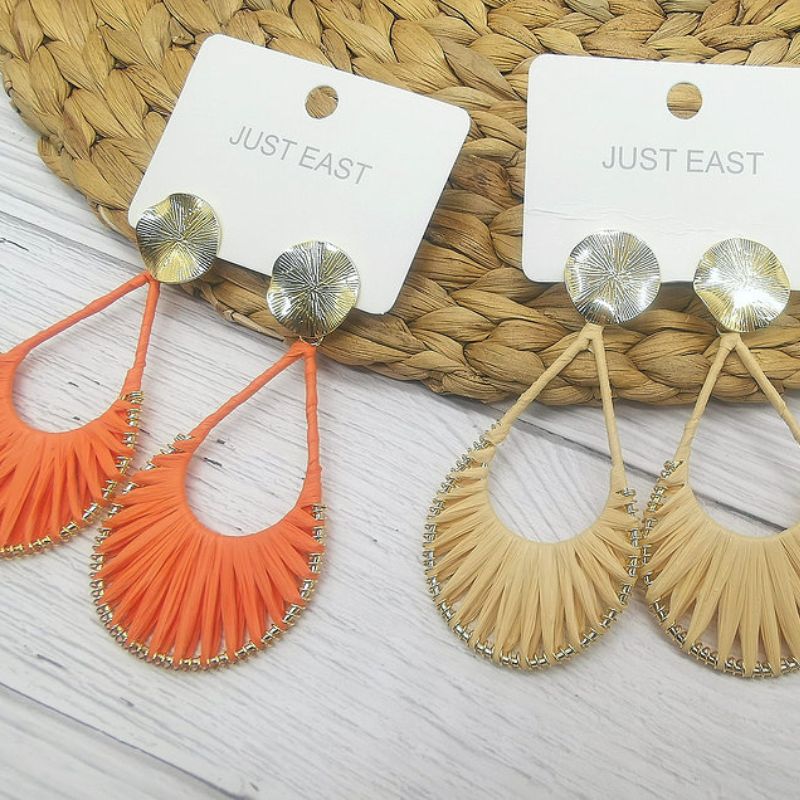 two pairs of straw dangle earrings, one orange and one cream pair